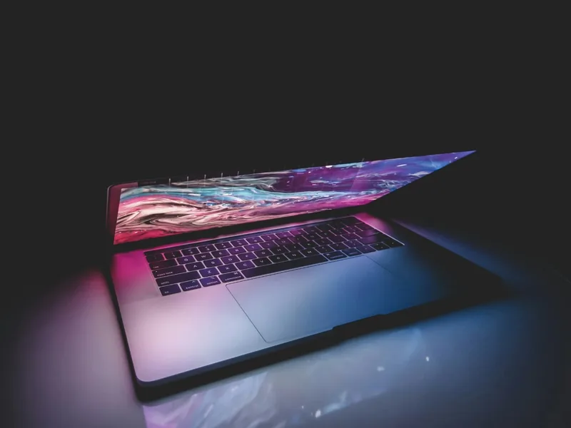 Geöffnetes MacBook mit farbig beleuchtetem Bildschirm.